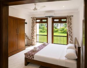 a bedroom with a bed and a large window at Nine Gems villa in Kandy
