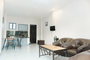 a living room with leather furniture and a table at Jared Suites in Upper Digos