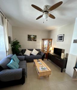 a living room with a couch and a ceiling fan at Casa Cal y Sol in Olvera
