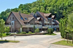 a large apartment building with a roof at Hôtel Les Rives in Guebwiller