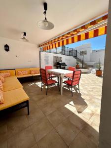 a living room with a table and red chairs at Casa Cal y Sol in Olvera