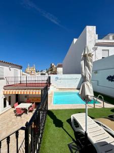 a balcony with a swimming pool and an umbrella at Casa Cal y Sol in Olvera