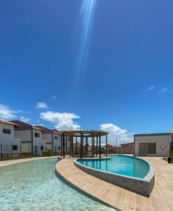 a swimming pool with a pavilion next to a building at Casas Carole Maramar Beach House 35 e 36 in Luis Correia