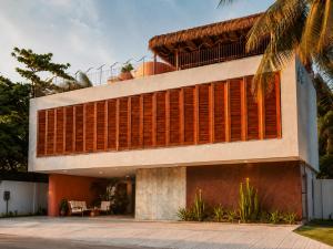 a house with wooden shutters on the side of it at Luau Hotel in Flecheiras