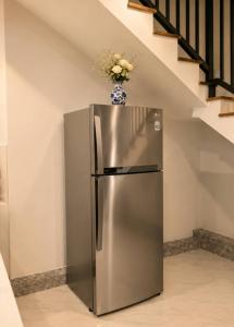 a stainless steel refrigerator with a vase of flowers on top at Nine Gems villa in Kandy