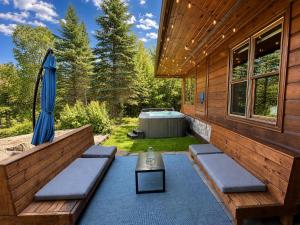 a patio with a hot tub and an umbrella at Howard Lodge & Spa in Saint Adolphe D'Howard