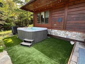 a small backyard with a jacuzzi tub on the side of a house at Howard Lodge & Spa in Saint Adolphe D'Howard