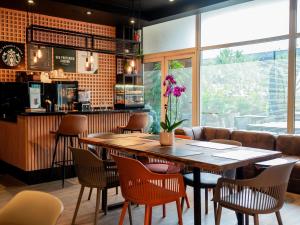 a restaurant with a large wooden table and chairs at ibis Guarulhos Aeroporto in Guarulhos