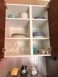 a kitchen cabinet filled with plates and dishes at Sala dell Estate Guest House in Secchia