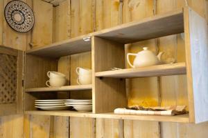 a wooden cabinet with plates and dishes on it at Šķilas in Pērkone