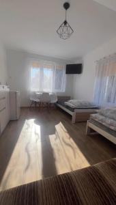 a room with two beds and a table and chairs at Kapitańska Przystań in Chłopy