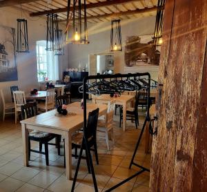 a dining room with wooden tables and chairs and chandeliers at Mooste mõisa Linakoja külalistemaja in Mooste +25 photos