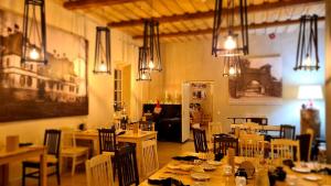 a dining room with tables and chairs and lights at Mooste mõisa Linakoja külalistemaja in Mooste