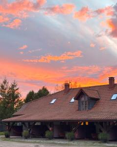 a roof of a house with a sunset in the background at Siedlisko Konradówka in Olecko