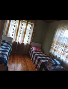 a bedroom with two beds and two windows at Kirayeev Hamarmeşə in Lerik +4 photos