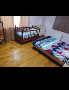 a bedroom with a bed and a wooden floor at Kirayeev Hamarmeşə in Lerik