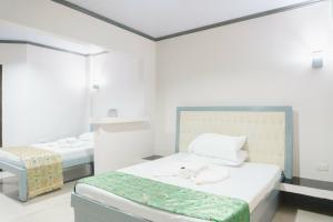a white room with a bed and a mirror at Jared Suites in Upper Digos +37 photos