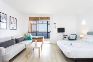 a white living room with a couch and a table at Don Rafael # Ocean views # Natural pools in Bajamar