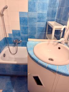a blue tiled bathroom with a sink and a shower at Appartamento elba da Susanna in Portoferraio