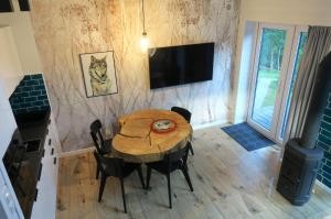 a dining room with a table and a television at Las Tu Las Tam in Chudaczewko