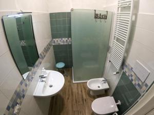 a bathroom with a sink and a toilet and a mirror at 99 Rooms in LʼAquila