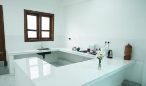 a white kitchen with a counter and a sink at Nine Gems villa in Kandy +100 photos