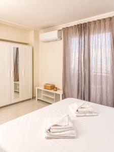 a bedroom with a white bed with two towels on it at polyxeni house in Lygia