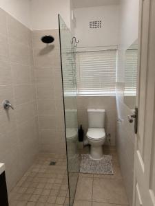 a bathroom with a toilet and a glass shower at The Oak in Strand +19 photos