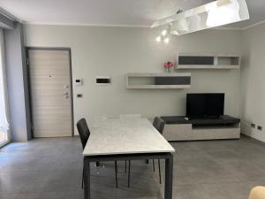 a living room with a table and a television at Residence Parco Castello 1 in Novi Ligure