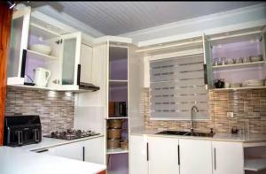 a kitchen with white cabinets and a sink at PENTHOUSE MPINGA RIMWEe in Kigali