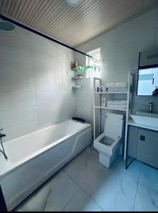 a bathroom with a tub and a toilet and a sink at PENTHOUSE MPINGA RIMWEe in Kigali +11 photos
