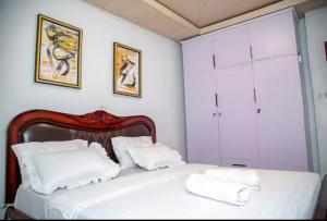a bedroom with a bed with white sheets and pillows at PENTHOUSE MPINGA RIMWEe in Kigali