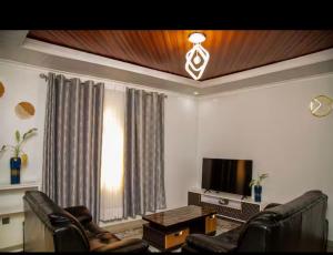 a living room with two chairs and a television at PENTHOUSE MPINGA RIMWEe in Kigali