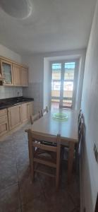 a kitchen with a wooden table and a dining room at EremAre Viareggio Casa Vacanza in Viareggio