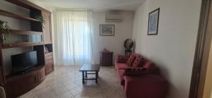 a living room with a red couch and a television at EremAre Viareggio Casa Vacanza in Viareggio