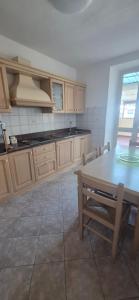 a kitchen with a table and a table and chairs at EremAre Viareggio Casa Vacanza in Viareggio +6 photos
