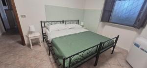 a bedroom with a bed with a green and white blanket at EremAre Viareggio Casa Vacanza in Viareggio