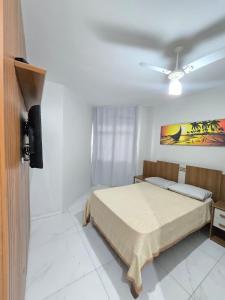 a bedroom with a bed and a ceiling fan at Praia Morro Katia apartamentos - Edificio Porto Belo in Guarapari