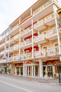 a large white building with balconies on a street at Hotel Kosta Famissi in Kalabaka