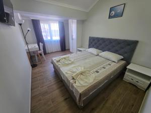 a bedroom with a large bed and a desk at Apartments Dani in Pomorie