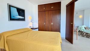 a bedroom with a bed and a wooden cabinet at MEDES PARK II 4-3 in L'Estartit +22 photos