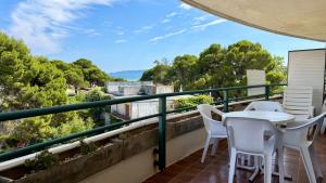 a balcony with a table and chairs and trees at MEDES PARK II 4-3 in L'Estartit