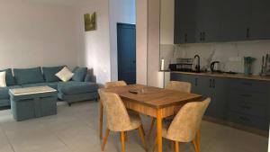 a living room with a wooden table and a blue couch at Pinevillasadgeri in Borjomi