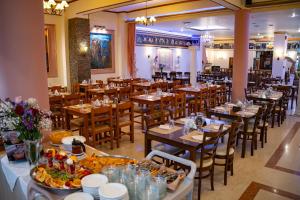 a restaurant with tables and chairs with food on them at Hotel Kosta Famissi in Kalabaka