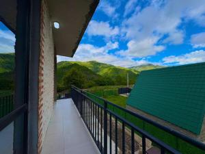 a balcony of a house with a view of mountains at Pinevillasadgeri in Borjomi