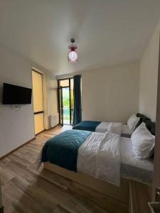 a bedroom with a bed and a flat screen tv at Pinevillasadgeri in Borjomi
