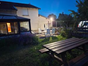 a wooden picnic table in the yard of a house at Gîte Marie des Côtes in Hannonville-sous-les-Côtes