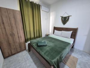 a bedroom with a bed with a green blanket on it at Skyview Apartment- Rooftop Penthouse with Sunset & Sea Views in Flic-en-Flac +95 photos