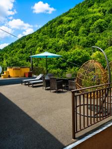 a patio with chairs and a bird cage and an umbrella at Iezer Mountain Escape in Lunca Ampoiţei +8 photos