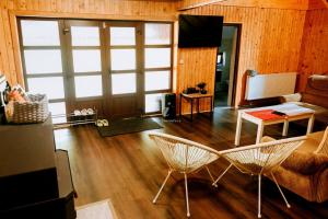 a living room with two chairs and a table at Iezer Mountain Escape in Lunca Ampoiţei